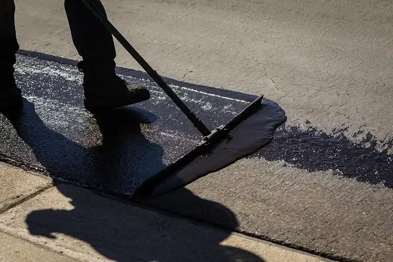 Applying sealcoating on an asphalt surface with a sealcoating applicator